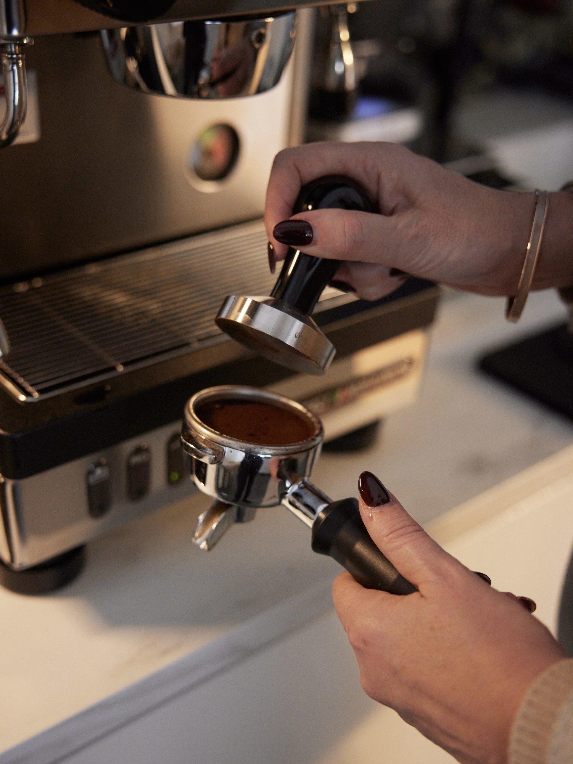 Barista bereitet Espresso in der La Cimbali M21 Junior im RE/MAX Starnberg Büro zu