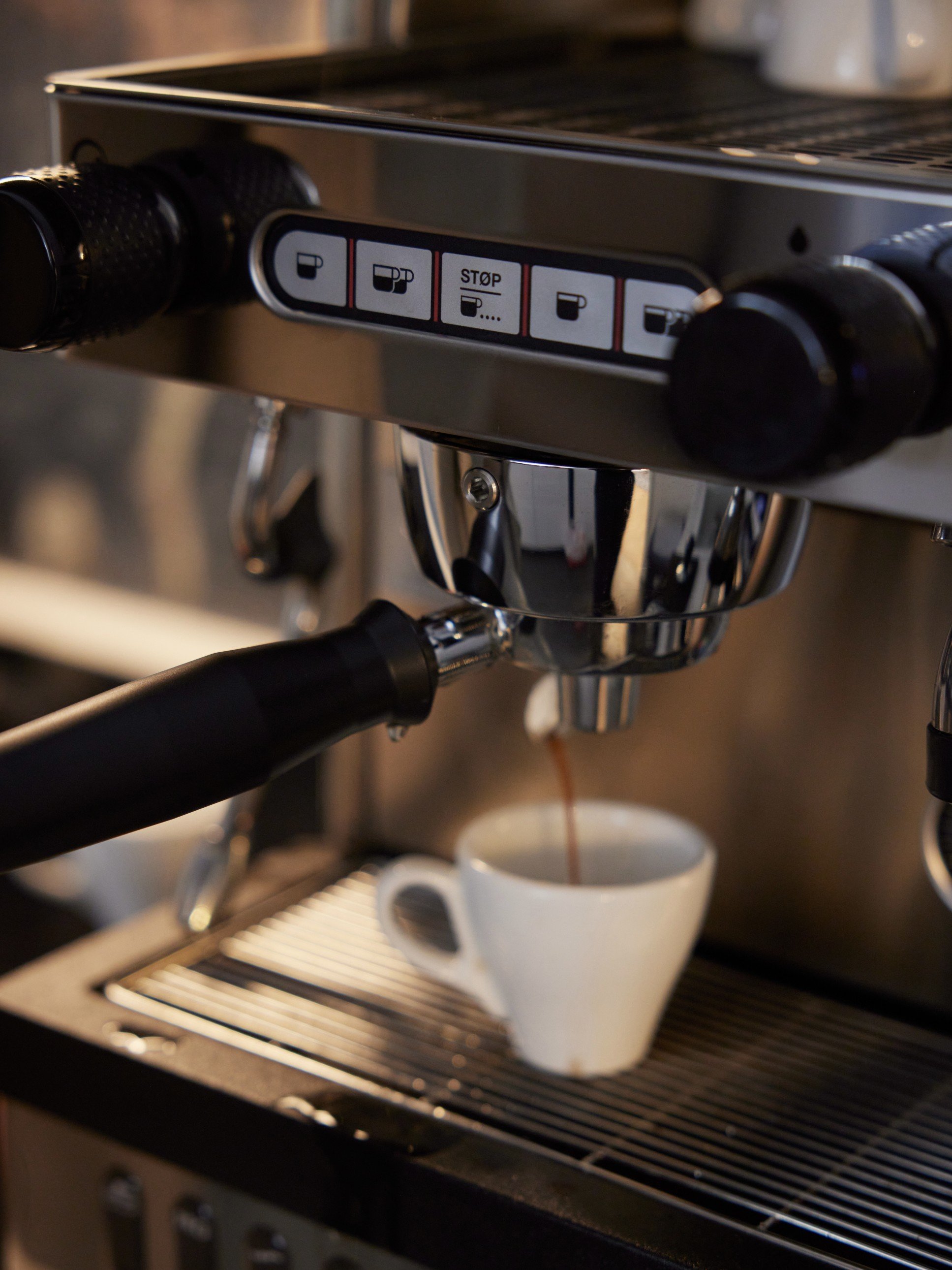 Frisch gebrühter Espresso fließt aus der La Cimbali M21 Junior in die Tasse im RE/MAX Starnberg Büro